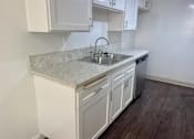 Thumbnail 14 of 26 - A kitchen with white cabinets and a marble countertop. at Copa Triana Apartments, Torrance