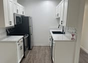 Thumbnail 25 of 54 - A kitchen with white cabinets and a black fridge. at Camino de Oro Apartments, Torrance, CA, 90505