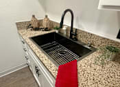 Thumbnail 49 of 55 - A kitchen counter with a sink and a red towel at Willow Tree Apartments, California, 90505