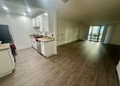 Thumbnail 50 of 55 - A kitchen with white cabinets and a wooden floor at Willow Tree Apartments, California, 90505