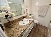 Thumbnail 48 of 55 - A bathroom with a granite countertop and a white sink at Willow Tree Apartments, California, 90505