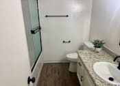 Thumbnail 51 of 54 - A bathroom with a toilet, sink, and shower.