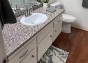 Thumbnail 39 of 40 - A bathroom with a marble countertop and a white toilet.
