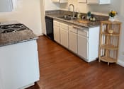 Thumbnail 40 of 40 - A kitchen with white cabinets and a wooden floor.