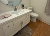 Thumbnail 30 of 40 - A bathroom with a white sink and toilet.