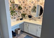 Thumbnail 16 of 25 - A bathroom with a floral wallpaper and a white vanity.