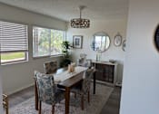 Thumbnail 17 of 25 - A dining room with a table and chairs.