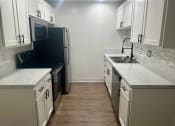 Thumbnail 38 of 55 - a kitchen with white cabinets and a sink and a refrigerator at Willow Tree Apartments, California, 90505