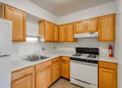 Thumbnail 2 of 10 - a kitchen with white appliances and wooden cabinets