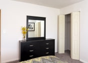 Thumbnail 14 of 25 - a bedroom with a dresser with a mirror and a closet