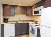Thumbnail 5 of 25 - a kitchen with white appliances and dark wood cabinets