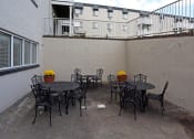 Thumbnail 12 of 25 - an outdoor patio with tables and chairs and a building in the background