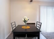 Thumbnail 1 of 25 - a dining room with a table and chairs and a vase of flowers