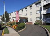 Thumbnail 7 of 25 - an apartment building with a pink flag in front of it