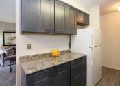 Thumbnail 10 of 25 - a kitchen with black cabinets and a white refrigerator