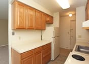Thumbnail 24 of 25 - an empty kitchen with wooden cabinets and a white refrigerator