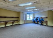 Thumbnail 6 of 14 - a large room with desks and chairs and a window