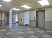 Thumbnail 14 of 14 - the lobby of a building with doors and a tiled floor