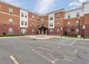 Thumbnail 3 of 14 - an empty parking lot in front of a brick building