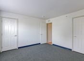 Thumbnail 5 of 11 - a empty room with two doors and a door to a closet
