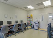 Thumbnail 7 of 11 - a computer room with desks and chairs and a filing cabinet