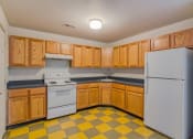 Thumbnail 6 of 11 - a kitchen with white appliances and wooden cabinets
