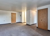 Thumbnail 4 of 10 - an empty living room with white walls and a wooden door
