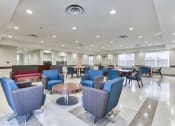 Thumbnail 7 of 15 - a common area with chairs and tables in a large room