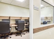 Thumbnail 6 of 15 - an office with desks and chairs and a window
