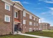 Thumbnail 4 of 15 - the outlook of a brick apartment building with a sidewalk