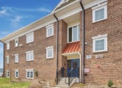 Thumbnail 1 of 15 - a brick apartment building with a porch and stairs