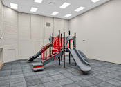 Thumbnail 37 of 50 - A red slide in a grey room.