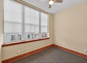 Thumbnail 31 of 50 - A room with a window overlooking a white house.