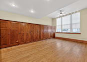 Thumbnail 29 of 50 - A room with wooden floors and a row of wooden cupboards.
