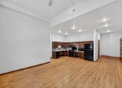 Thumbnail 33 of 50 - A kitchen area with wooden floors and white walls.