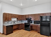 Thumbnail 28 of 50 - A kitchen with wooden cabinets and black appliances.