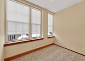Thumbnail 9 of 50 - A room with two windows and carpeted floor.