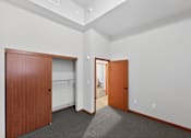 Thumbnail 32 of 50 - A room with two wooden doors and carpeted floor.