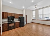 Thumbnail 3 of 50 - A kitchen with wooden floors and a black refrigerator.