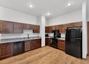 Thumbnail 4 of 50 - A kitchen with wooden cabinets and a black refrigerator.