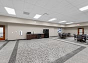 Thumbnail 42 of 50 - A room with a carpeted floor and a few chairs and tables.