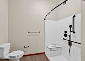 Thumbnail 25 of 50 - A white toilet sits next to a walk-in shower with a glass door.