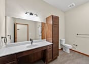 Thumbnail 26 of 50 - A bathroom with a white sink and a white toilet.