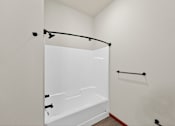 Thumbnail 12 of 50 - A white bathroom with a white tub and a white shower curtain.