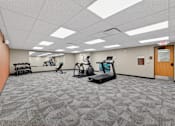 Thumbnail 44 of 50 - A spacious gym with treadmills, exercise bikes, and other equipment.