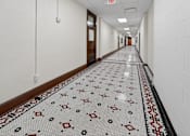 Thumbnail 46 of 50 - A long hallway with a tiled floor and white walls.