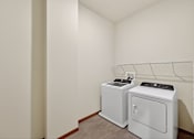Thumbnail 16 of 50 - A small laundry room with a washer and dryer.