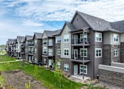 Thumbnail 24 of 28 - A row of modern townhouses with balconies and front yards.