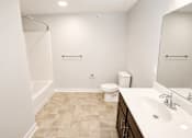 Thumbnail 7 of 28 - A bathroom with a toilet, sink, and shower.