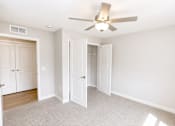 Thumbnail 2 of 28 - A room with a ceiling fan and two doors.